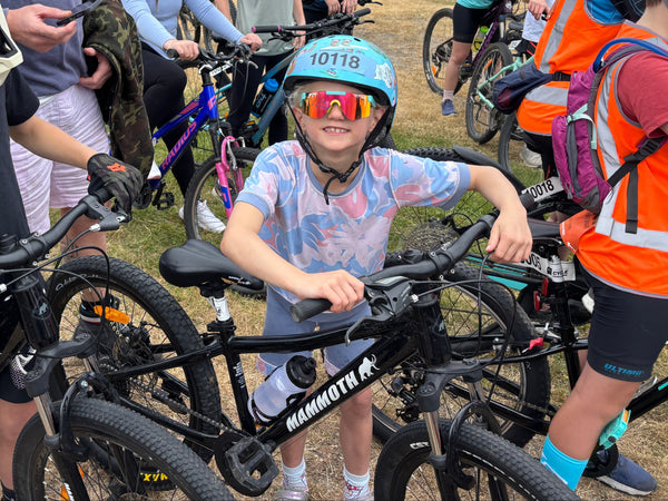 Children with bicycles and helmets at a cycling event in aszo clothing sensory-friendly clothing crop top and bike pants.